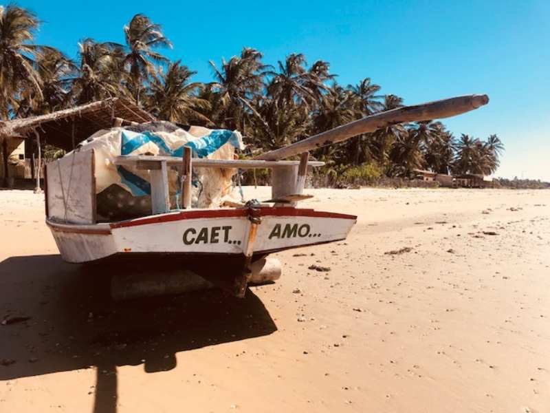 Guia local mostrando a paisagem da Praia de Caetanos para turistas durante passeio de turismo comunitário