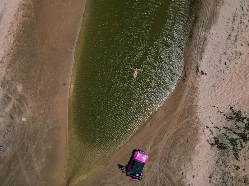 Lagoa cristalina dos Lençóis Cearenses em Caetanos rodeada por dunas de areia branca e vegetação típica da caatinga