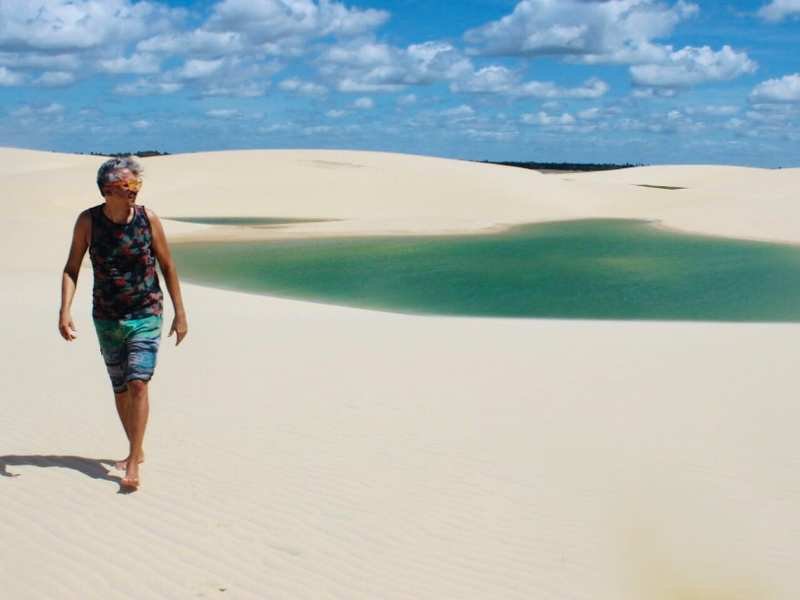 Vista panorâmica da Praia de Caetanos com duna ao fundo e extensão de areia branca à beira mar